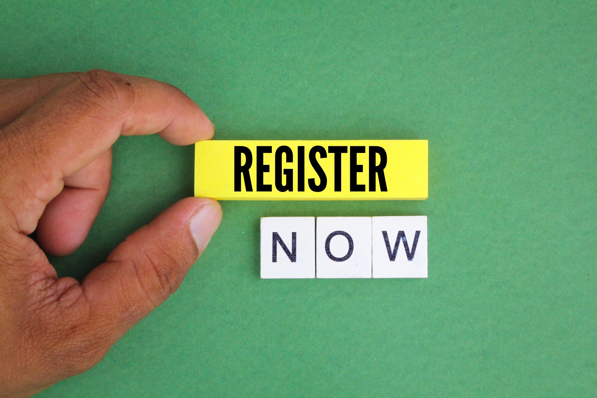 alphabet letters and colored paper with the word register now.