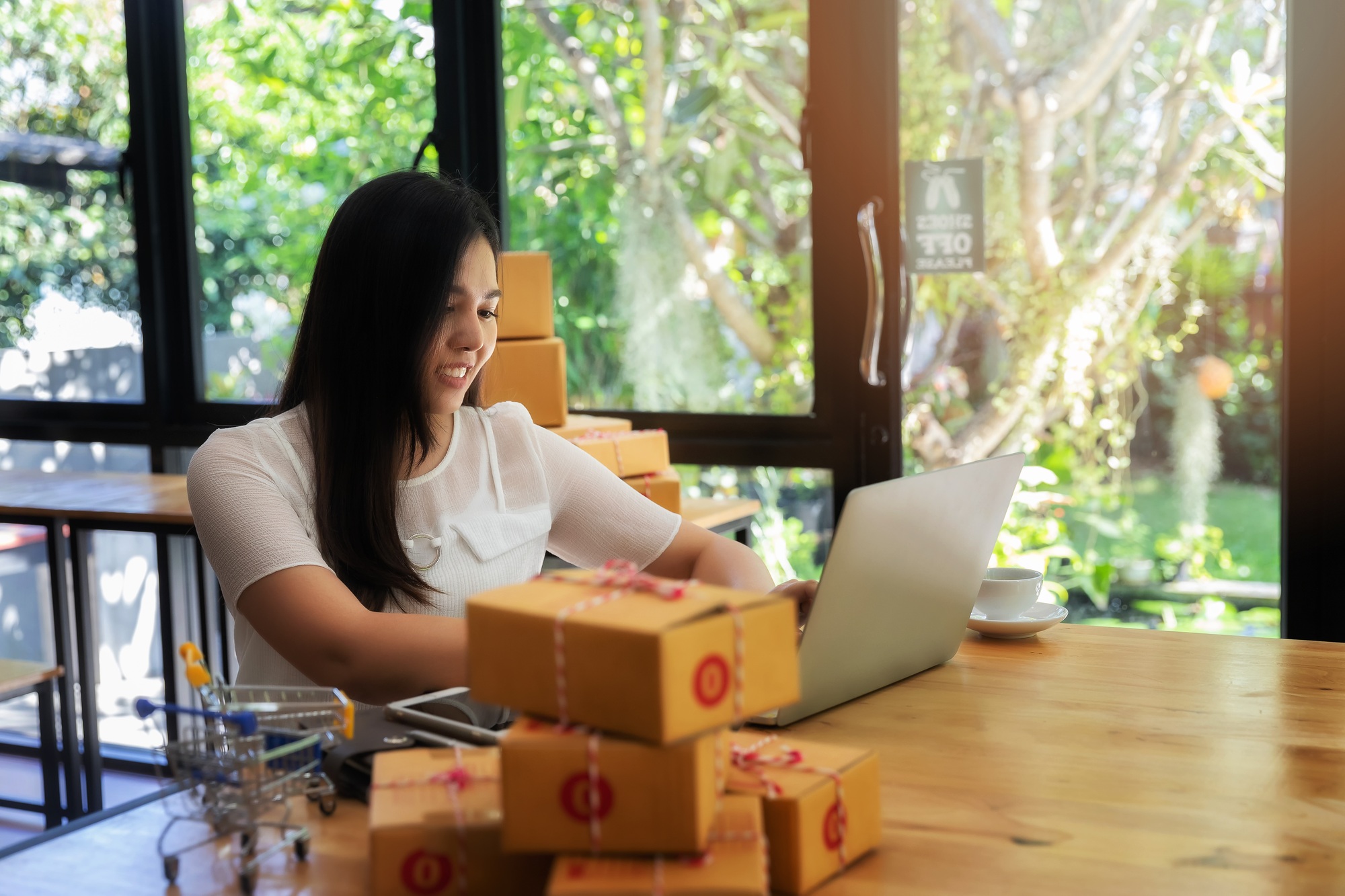 business woman with online sales and Parcel shipping in her home office.