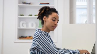 Businesswoman typing on laptop at office desk