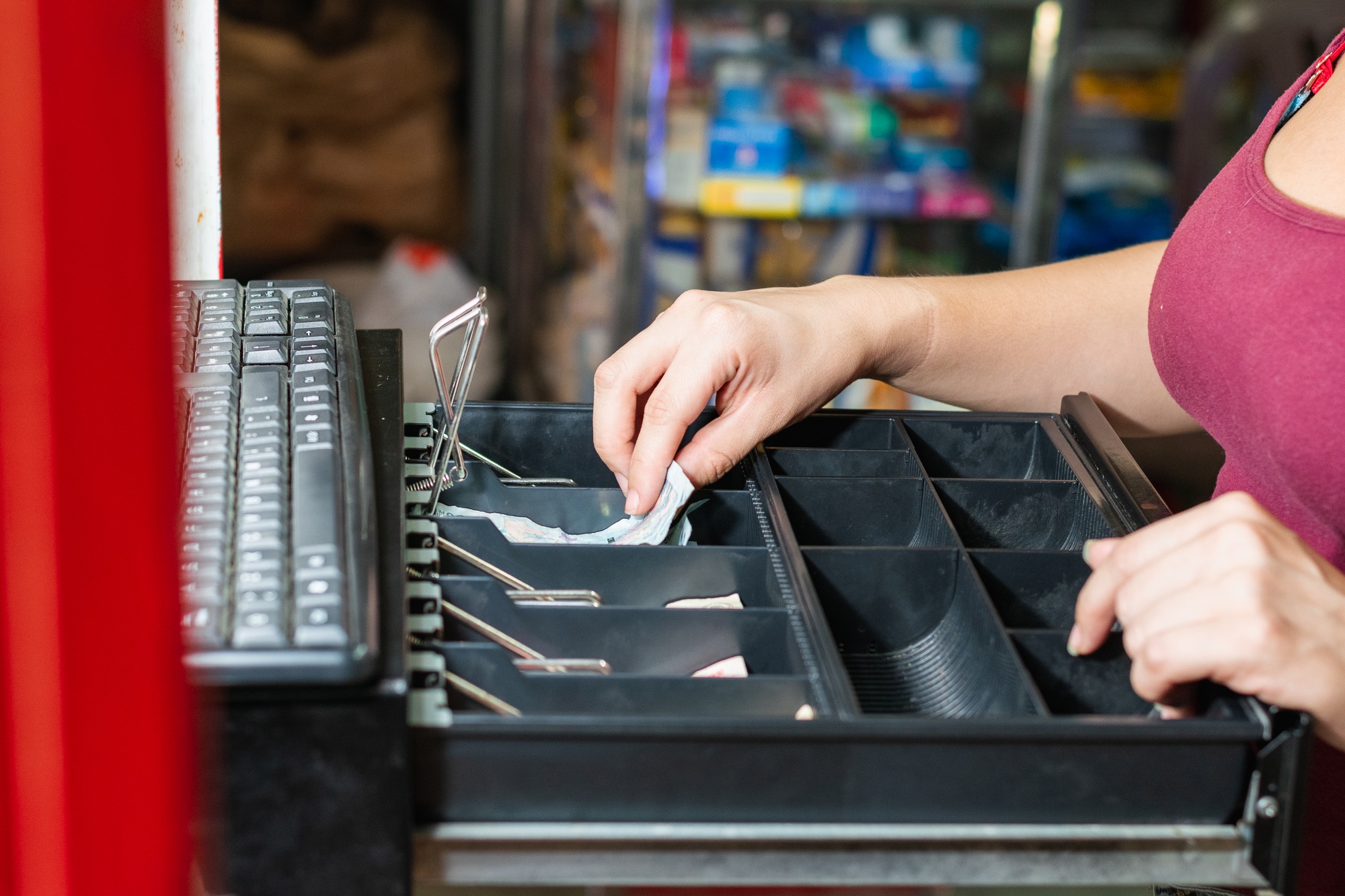 hand of an enterprising woman in her business opening the cash register. in front of cash register