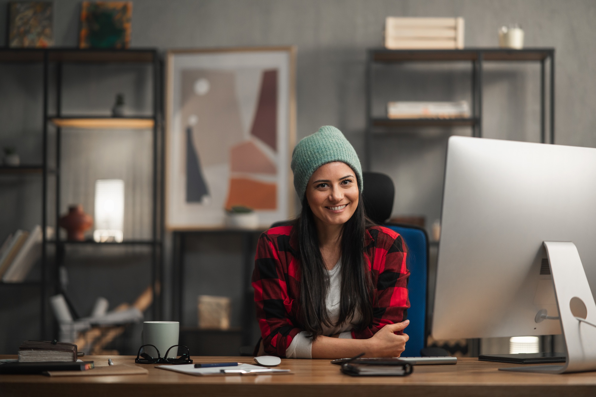 Happy female video editor works indoors in creative office studio, looking at camera