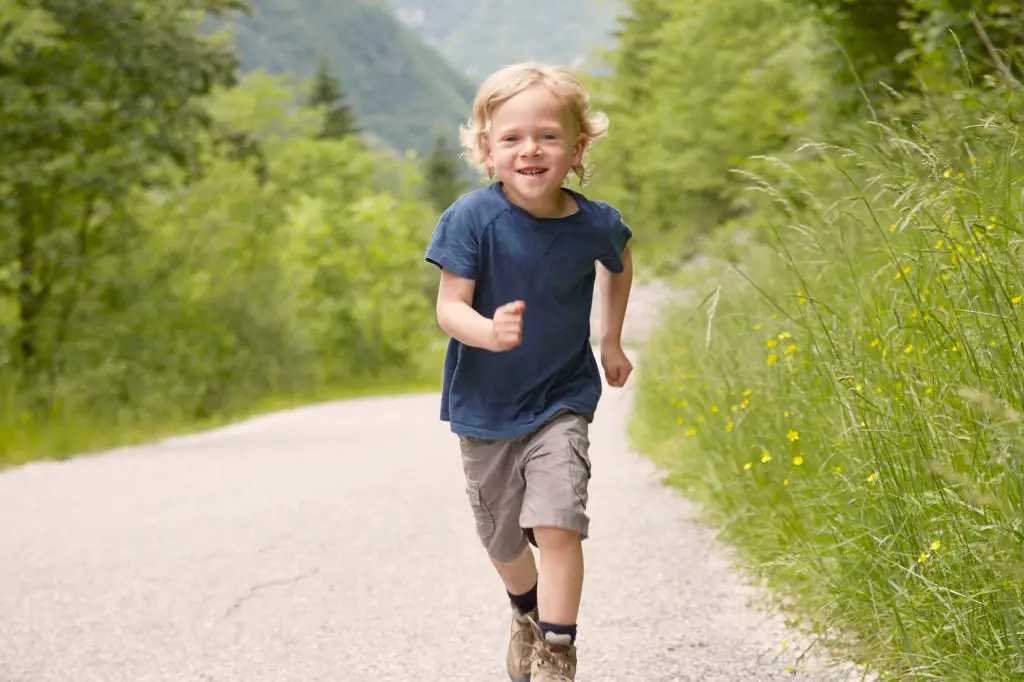 Joyful child running on a sunny nature trail