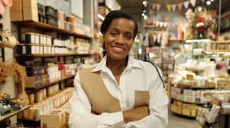 Portrait of Woman Standing in Well-Stocked Store Smiling