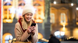 Shopper woman buying online on the smart phone at Christmas. People shopping communication concept