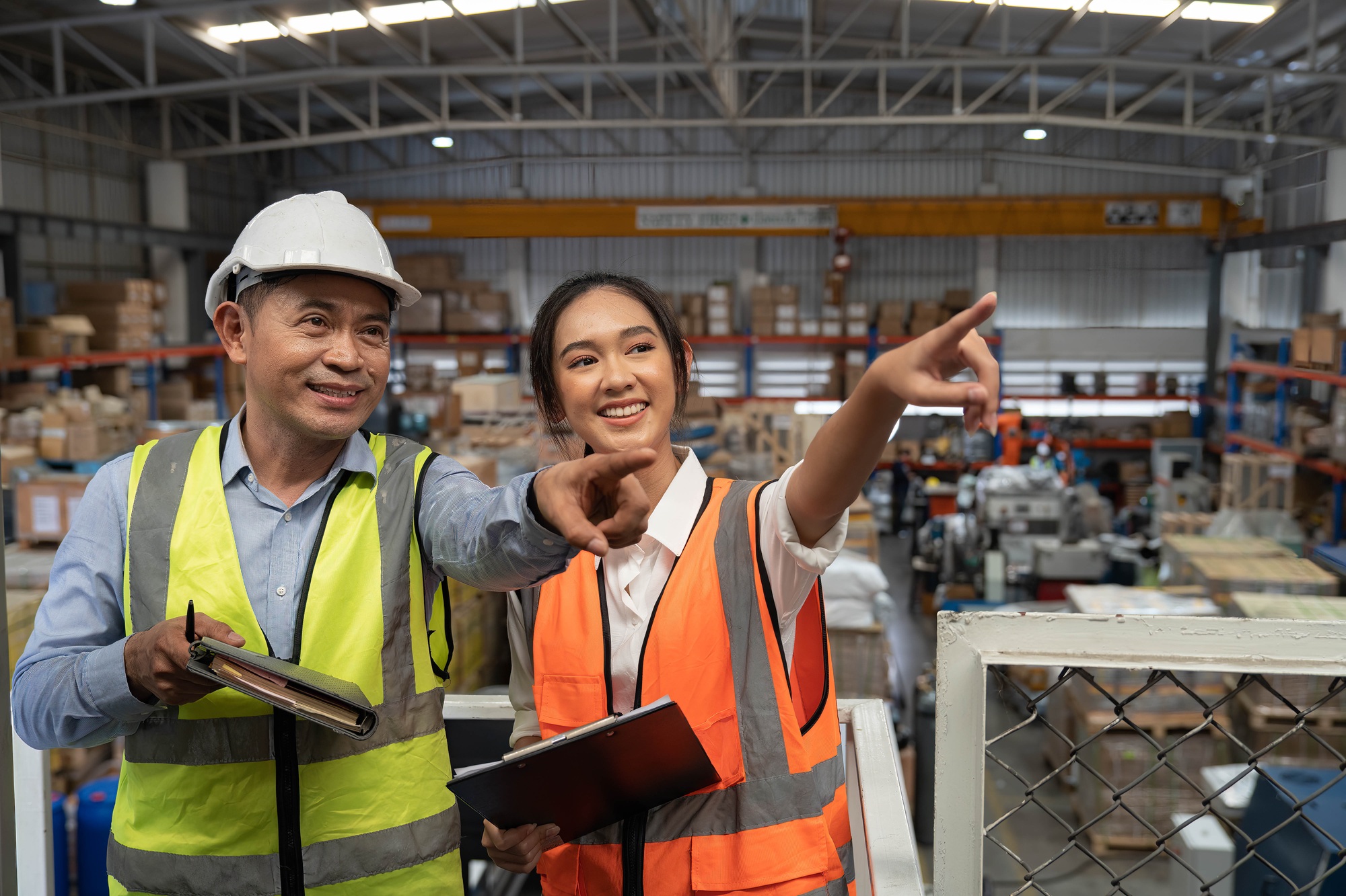 Staff and manager working in warehouse checking inventory list and storage shelf location
