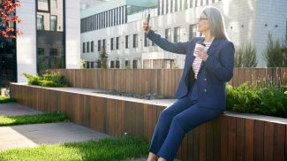 Successful business-lady taking a photo of herself in fancy suit