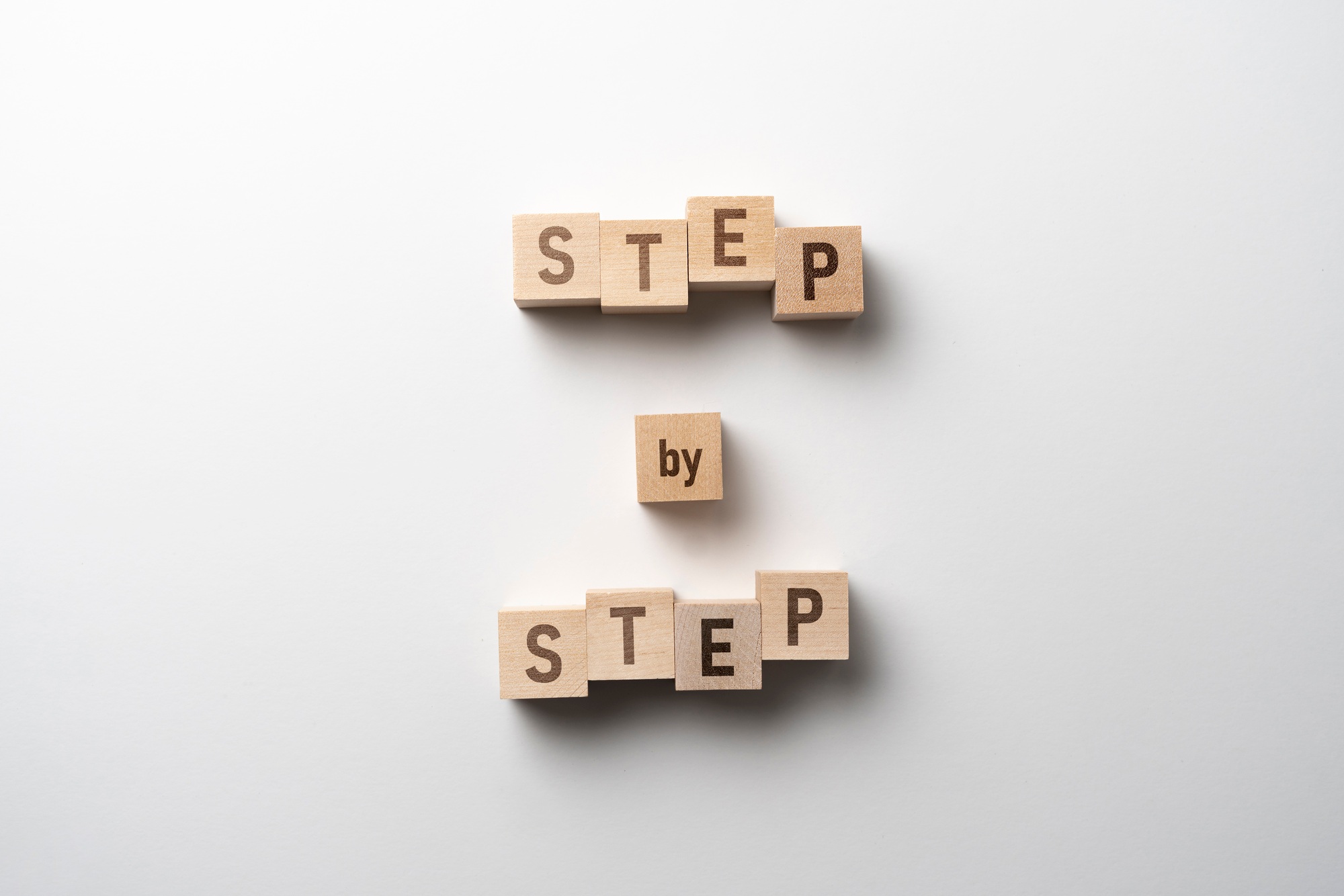 the wooden cubes blocks with "step by step" text, personal growth concept