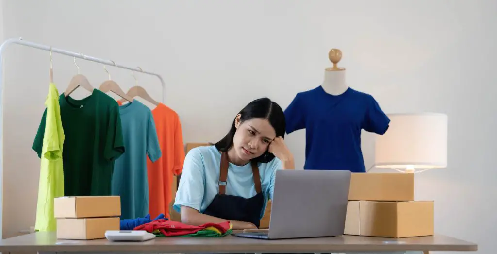 Woman seller SME retail store owner work hard worry stress in bad news on laptop at home office desk