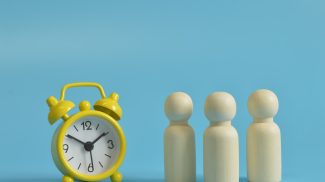 Wooden figures of people with clock. The concept of time planning.